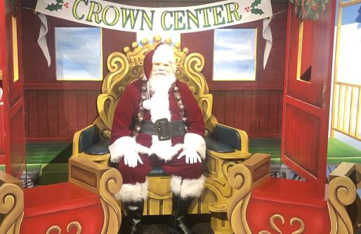 Santa sitting in chair in Gingerbread Station