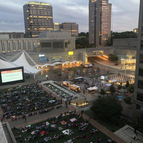 WeekEnder:  Movie screen with people sitting on chairs and blankets, food trucks on lower square